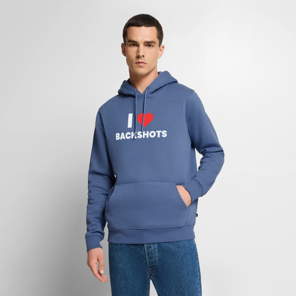 Nahaufnahme des bärtigen Models, das den taubenblauen PrideMerch-Hoodie präsentiert. Die lockere Passform und die markante Grafik auf der Brust zeigen ein stolzes, humorvolles Mode-Statement für die Community.