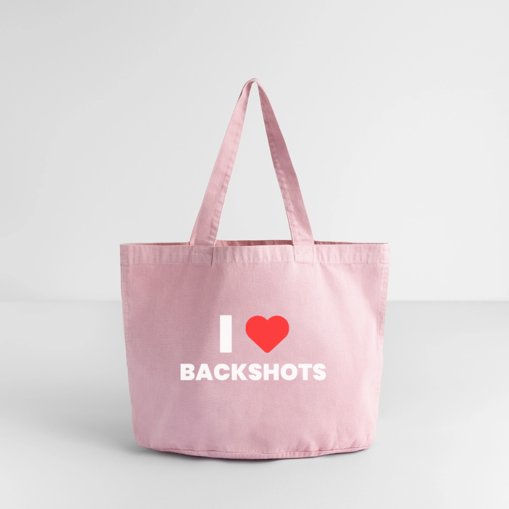 Rückansicht der gewaschenen, rosafarbenen Baumwolltasche, präsentiert in einer minimalistischen Studio-Umgebung auf weißem Boden. Dank des doppelten Aufdrucks ist das provokante Motiv aus rotem Herz und schwarzer Typografie von beiden Seiten sichtbar.