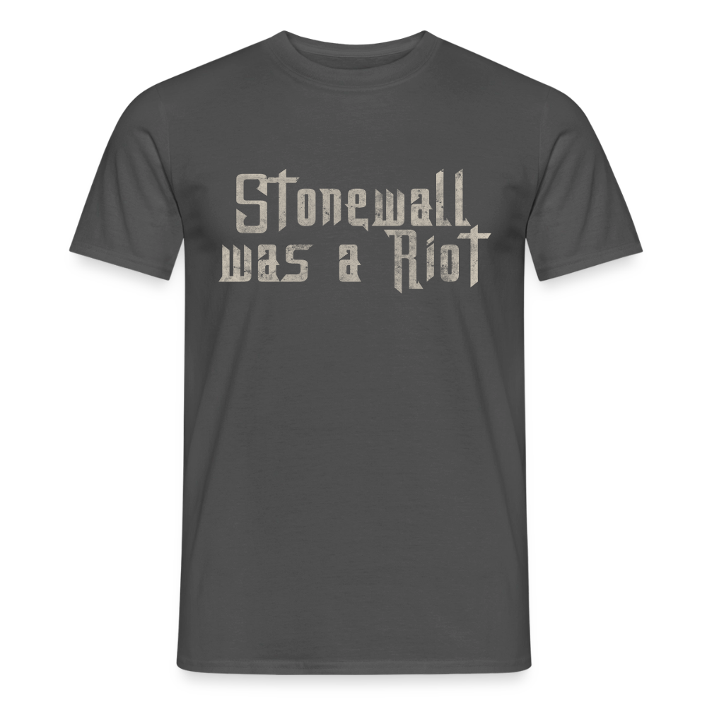 Das dunkelgraue (anthrazitfarbene) T-Shirt zeigt den zentrierten Statement-Print „Stonewall was a Riot“. Die helle Stencil-Schrift im Used-Look hebt sich deutlich vom dunklen Stoff ab und symbolisiert queeren Widerstand.