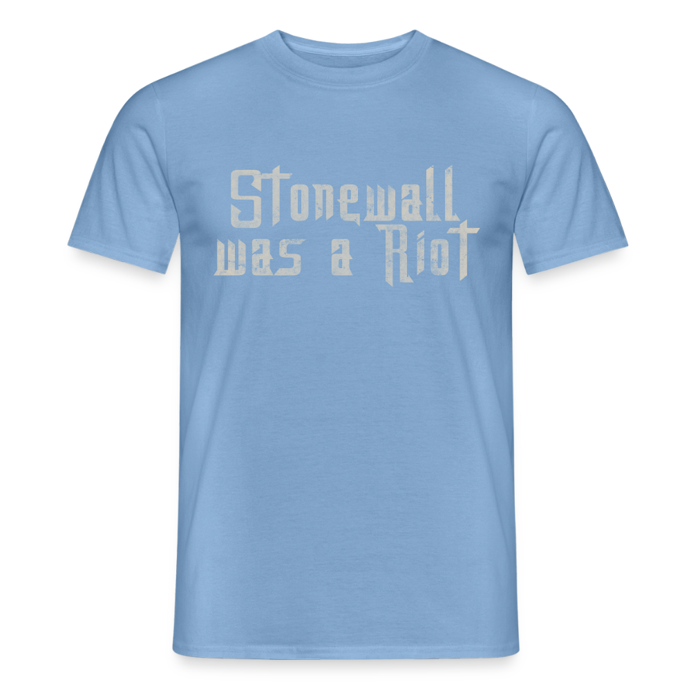 Auf dem hellblauen (Carolina Blue) T-Shirt prangt die Botschaft „Stonewall was a Riot“. Die verwitterte Stencil-Schrift verleiht dem Shirt eine authentische, aktivistische Note.