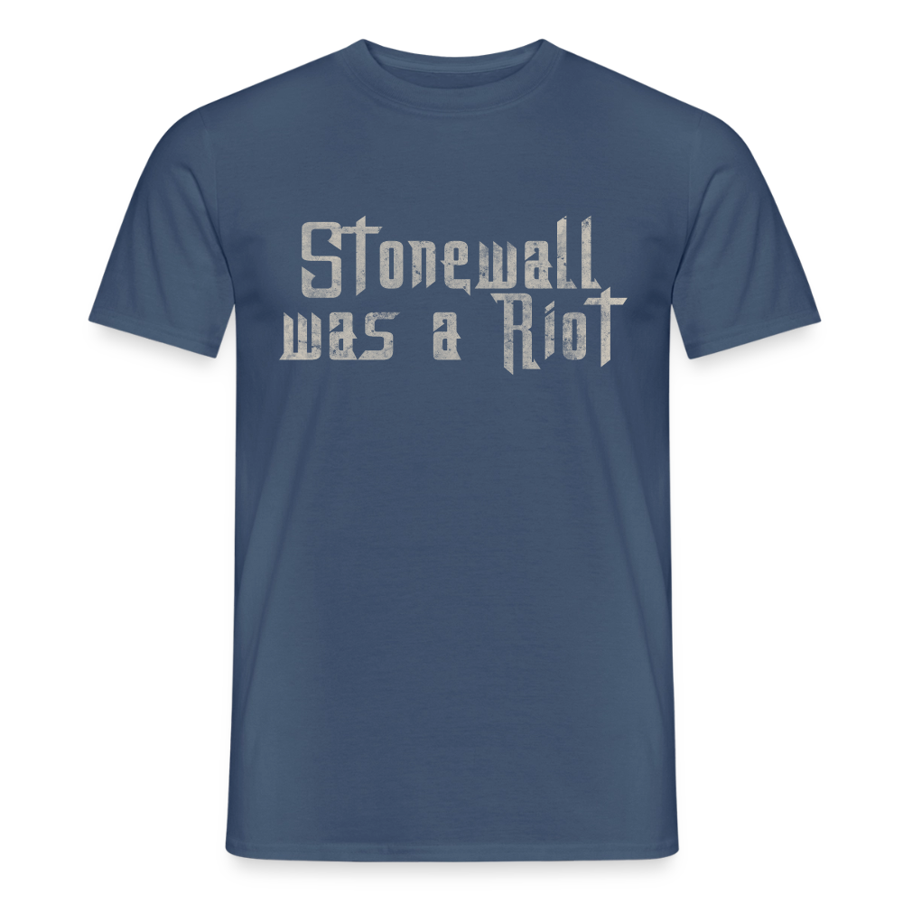 Freigestelltes Shirt in dunklem Denimblau. Der helle Stencil-Print „Stonewall was a Riot“ erinnert mit seiner rauen Textur an die historischen Kämpfe der LGBTIQ-Community.