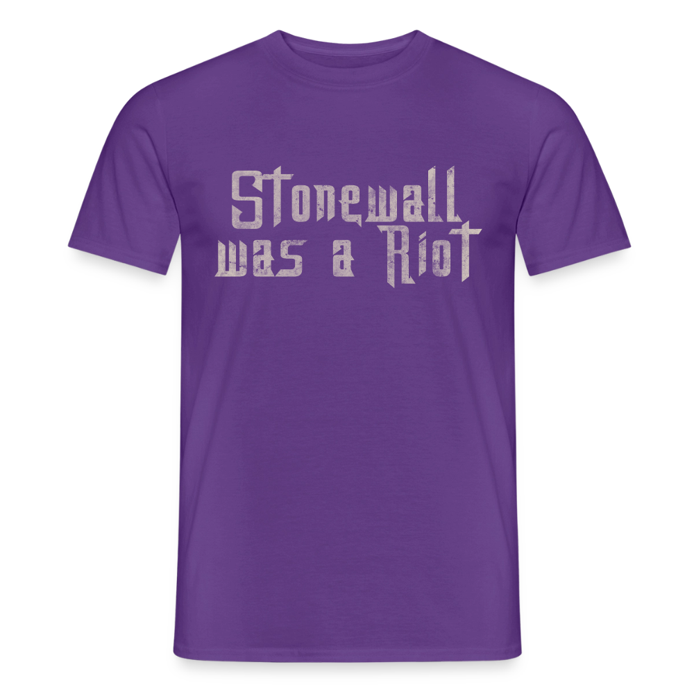 Lila T-Shirt mit dem zentrierten Print „Stonewall was a Riot“. Die Stencil-Typografie im Used-Look erinnert an die Anfänge der Kämpfe für queere Befreiung.