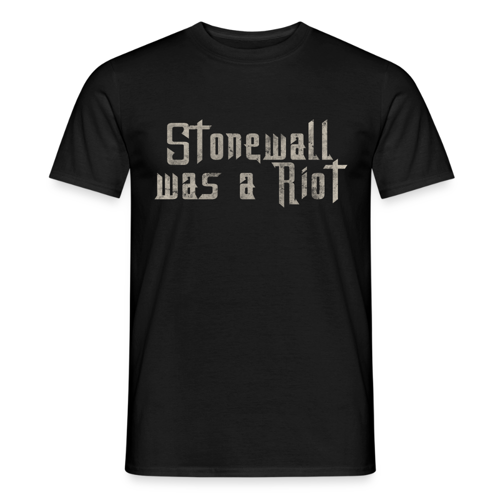 Klassisches schwarzes T-Shirt, auf dem der Stencil-Schriftzug „Stonewall was a Riot“ hell hervorsticht. Die abgenutzte Optik der Buchstaben erinnert an politische Street-Art.