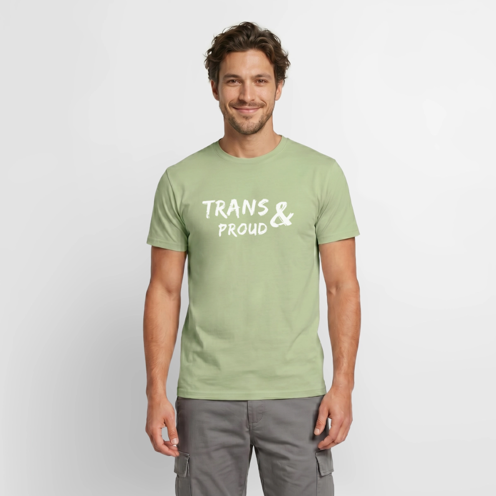 Ein männliches Modell präsentiert das salbeigrüne Menschenrechts-T-Shirt. Die helle, präzise „TRANS AND PROUD“-Grafik auf der Brust setzt ein stolzes, politisches Statement für geschlechtliche Selbstbestimmung und Vielfalt.