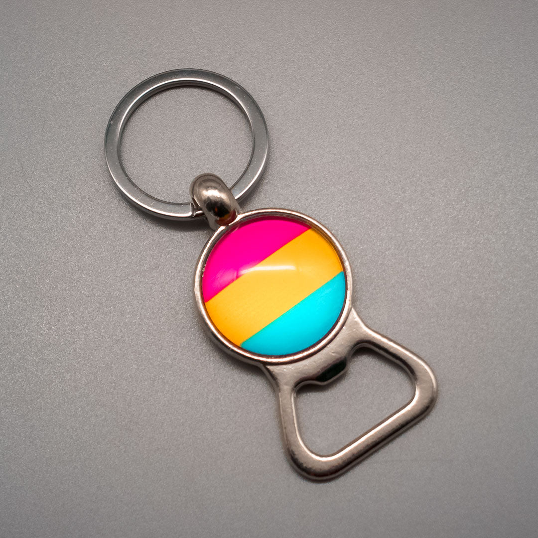 Total Ansicht eines Schlüsselanhängers mit einem Flaschenlöffner und der Pansexuell-Pride-Flagge in der Mitte unter eine Glaskuppel
