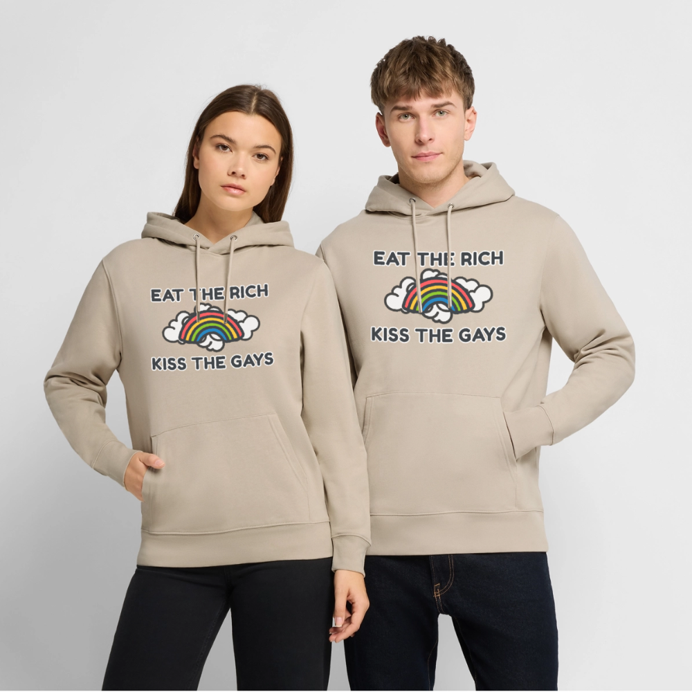Präsentation des beigen Kapuzenpullovers mit dem aktivistischen Statement „Eat The Rich Kiss The Gays“ an einem Model. Der bunte Regenbogen verbindet Antikapitalismus mit queerer Lebensfreude auf der Straße.