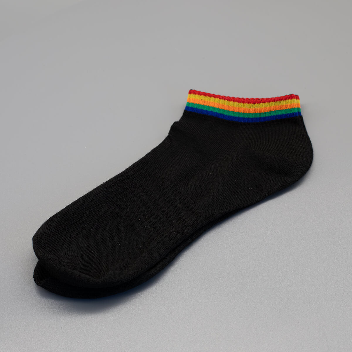 Die bunten Pride-Farben umschließen bei dieser Variante als schmale Ringe den oberen elastischen Bund. Die tiefschwarzen Kurzsocken sind flachgelegt und sauber für den Onlineshop freigestellt, um die visuelle Platzierung der Streifen zu betonen.