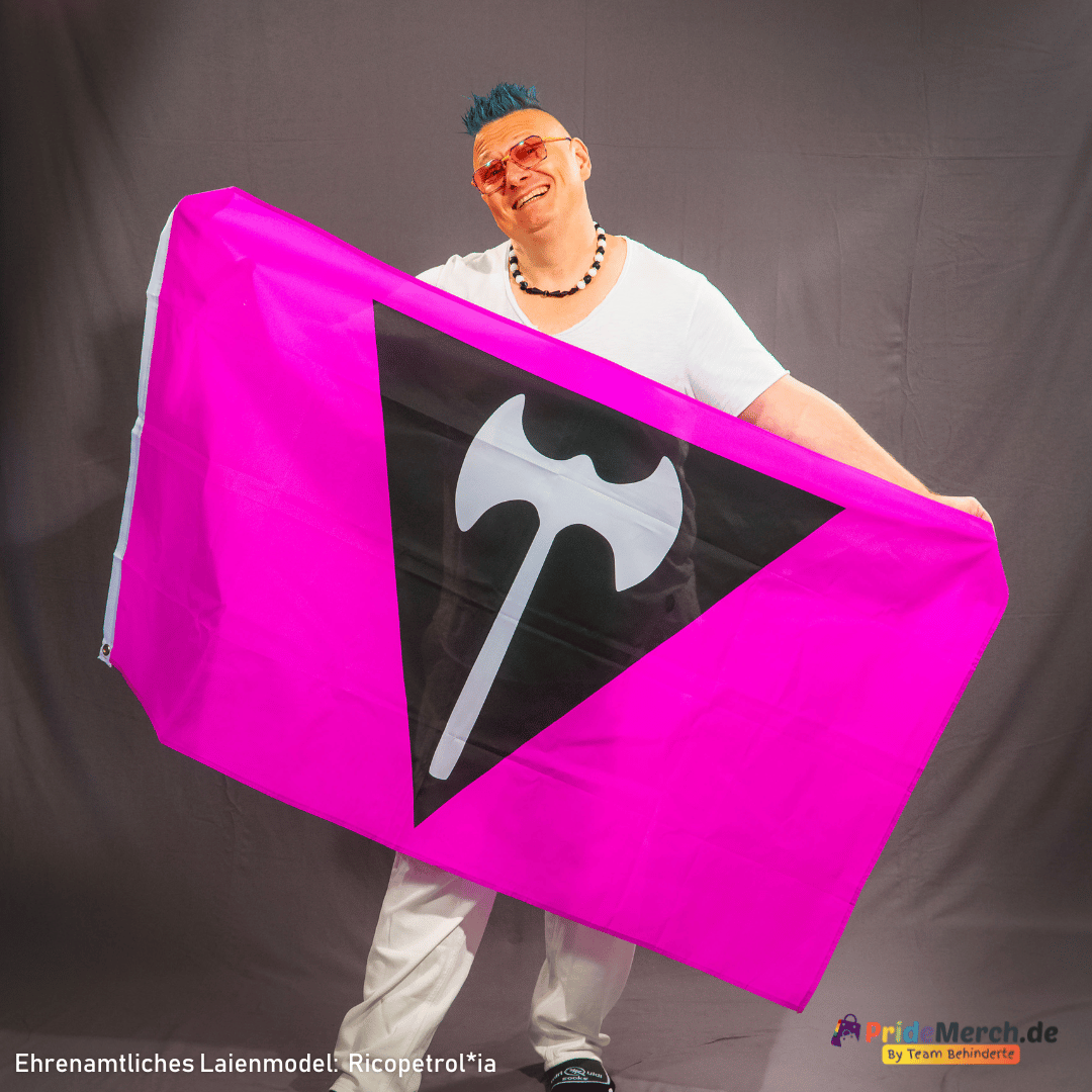 Das ehrenamtliche Laienmodell Ricopetrol*ia posiert fröhlich lächelnd im Fotostudio mit der violetten Labrys Lesben Pride Flagge. Die leichte Polyester-Fahne wird aufrecht gehalten und bringt das schwarze Dreieck-Design optimal zur Geltung.