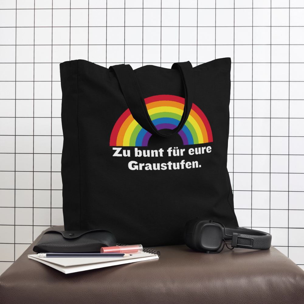 Schwarze Pride Tote Bag in einer coolen Lifestyle-Szene auf einem Hocker vor weißer Fliesenwand