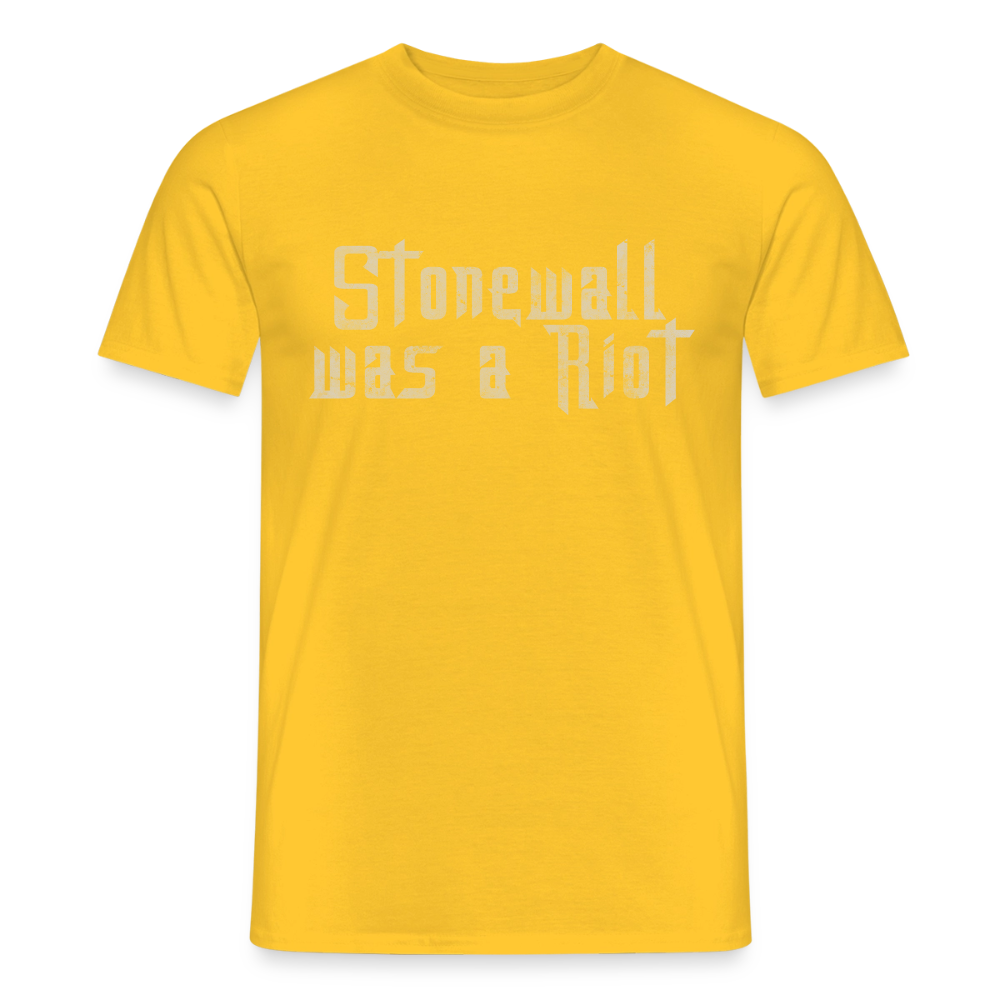 Sonniges gelbes T-Shirt mit dem rauen Stencil-Schriftzug „Stonewall was a Riot“. Das kontrastreiche Design rückt die historische Bedeutung des Aufstands in den Fokus.