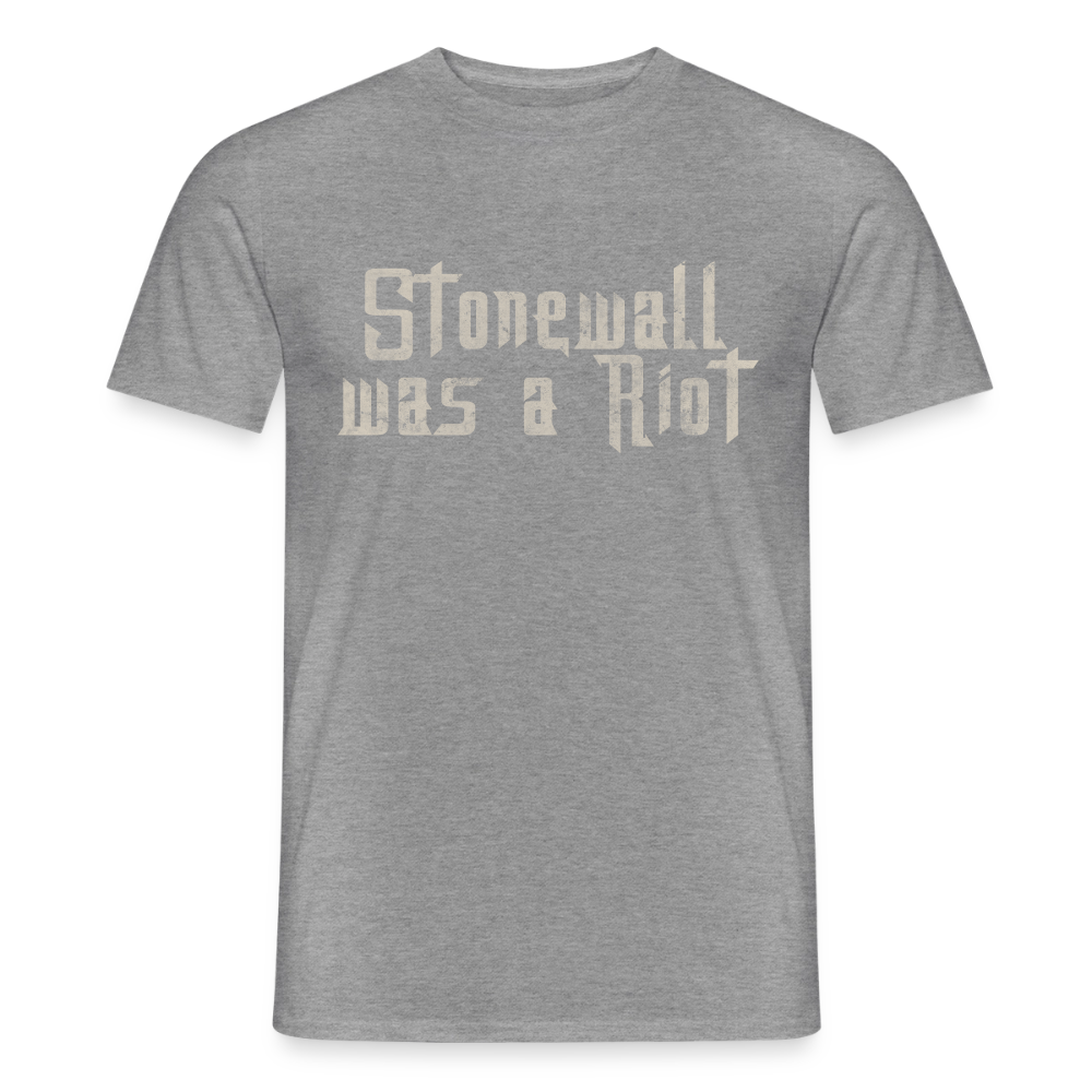 Zentrierte Typografie im Stencil-Look auf einem graphit-melierten T-Shirt. Der Schriftzug „Stonewall was a Riot“ wirkt durch seine verwitterte Textur wie aufgesprüht und erinnert an die Wurzeln des CSD.