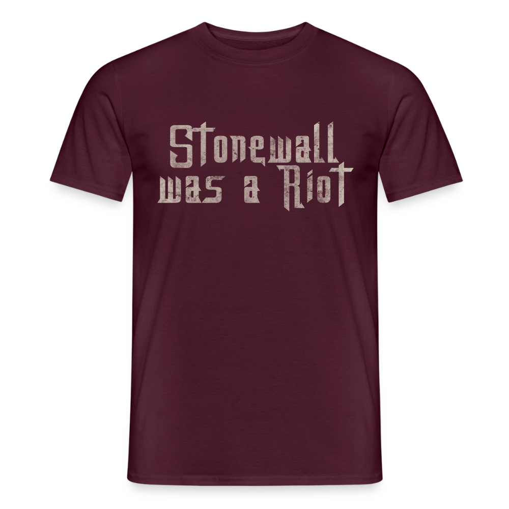 Das ziegelrote T-Shirt präsentiert die aktivistische Botschaft „Stonewall was a Riot“. Die helle Typografie im Used-Look steht symbolisch für die ungeschönte Geschichte der queeren Befreiungsbewegung.
