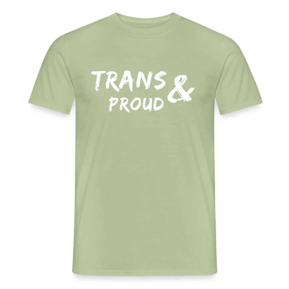 Ein salbeigrünes Aktivismus-T-Shirt, flach ausgelegt auf transparentem Hintergrund. Auf der Brust befindet sich der feine weiße Schriftzug „TRANS AND PROUD“, unterstrichen von den farbigen Streifen der Trans-Flagge für politische Sichtbarkeit.
